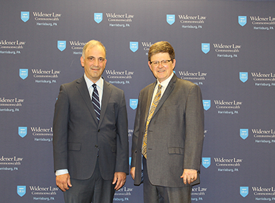Image of Judge Bianco and Professor Christian Johnson standing in front of the Widener Law Commonwealth step and repeat in A180.