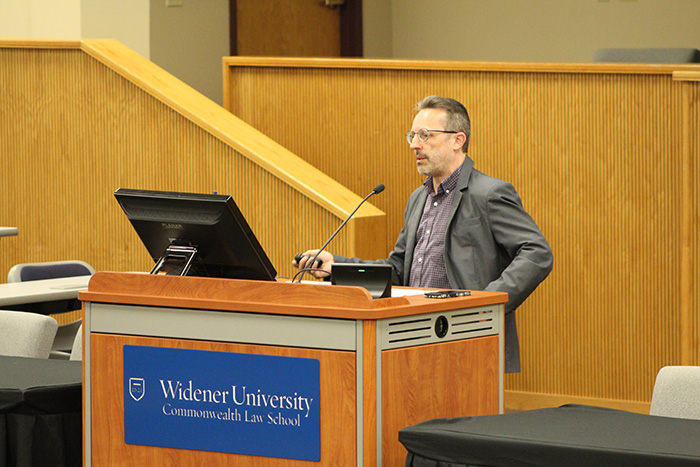 Image of Scott Caron behind the podium giving a lecture to first-year students.