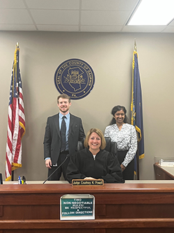 Image of student externs standing with judge in court.