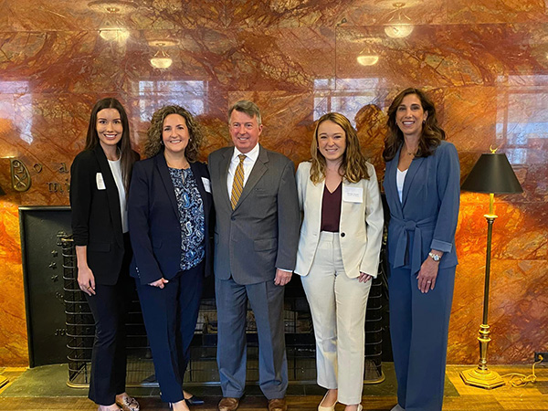 A group of five people dressed in suits stands inside the Dauphin County Courthouse, posing together in a professional setting.