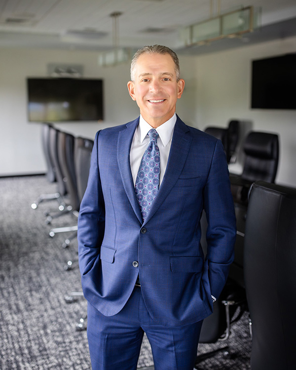 Image of Rory Ritrievi standing in an office, smiling at the camera.