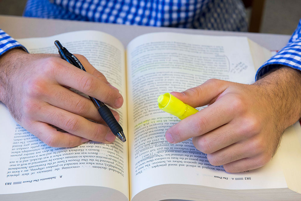 Picture of student highlighting a book.