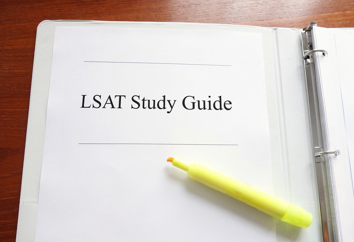 Image of LSAT Study Guide binder with a yellow highlighter laying on top of it.
