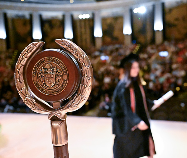 Image of Widener Law Commonwealth graduate crossing the stage after receiving their degree at the Forum in Harrisburg.