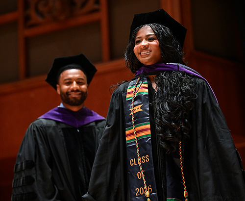 Image of Sierra Williams being hooded by her brother at commencement. 