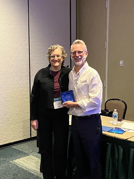 Image of Professor Jill Family standing with Professor David J. Reiss of Cornell Law School holding his award. 