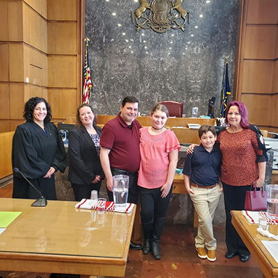 Image of Deborah Myers family and Judge Curcillo and Erin in the courtroom during the adoption process.