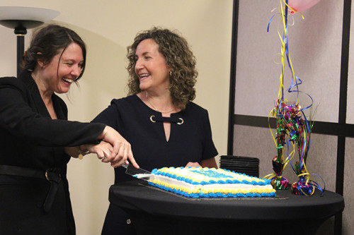 Mary Catherine Scott cuts a celebratory cake with Rebecca Waldemar