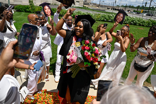 Student celebrating outside the forum with their family.