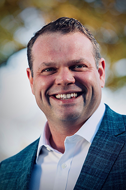 Image of Dan Kunze. He's wearing a blue blazer with a white shirt.