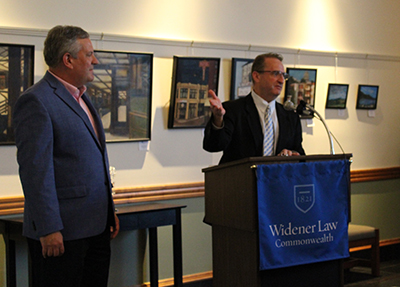 Dean andre douglas pond cummings speaking at a podium beside Michael Hussey.