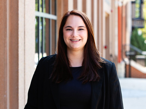 Image of Erika Firestone, wearing a black blazer and smiling at the camera. 