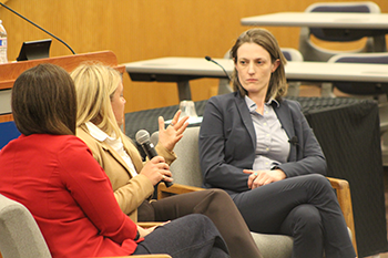 Image of Tara Schellhorn speaking with the microphone on the panle. 
