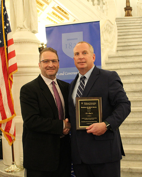 Nick Matash pictured with Dean cummings holding his award and smiling at the camera. 