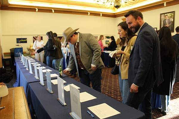 Image of crowd in the Dean's Gallery participating in the silent auction portion of the evening. 