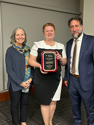 President Stacey Robertson standing with Prof. Amanda Sholtis and Provost Mark Nicosia.