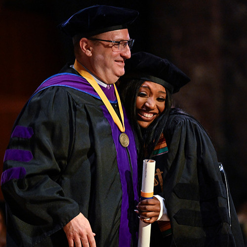 Image of Dean cummings posing with newly graduated student, Miss-Kye Gallon. 