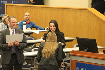 Image of students draping cords around their necks during the student awards ceremony.