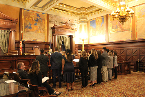 14 Widener Law Commonwealth graduates stand before the PA Supreme Court bench with their hands raised taking the oath. 