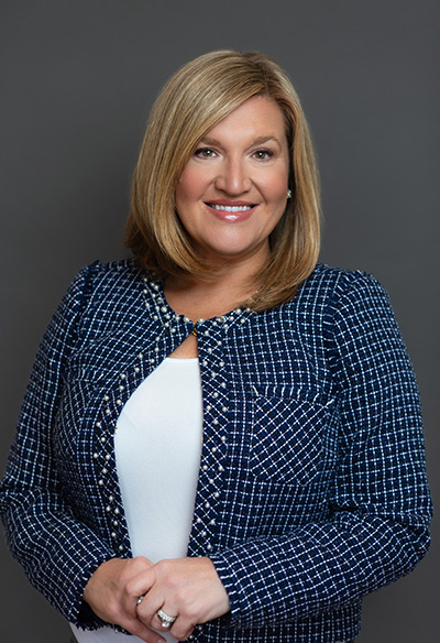 10:51 PMClaude responded: Kristen B.Kristen B. Hamilton: Smiling woman in a navy blue tweed blazer over a white top, hands clasped, against a neutral gray background.