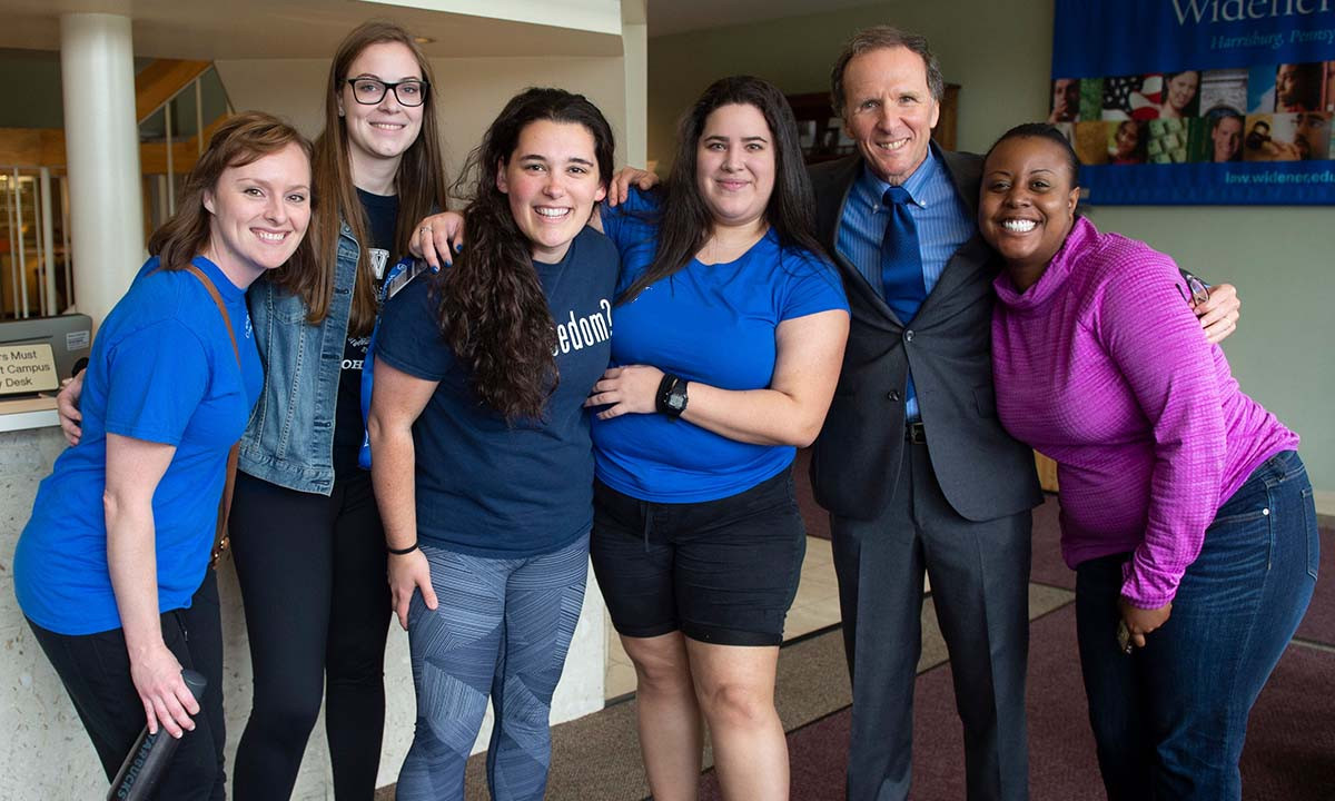 A group of five law students and the Law School Dean smiling and posing together during the Dean's Picnic event at Widener University.