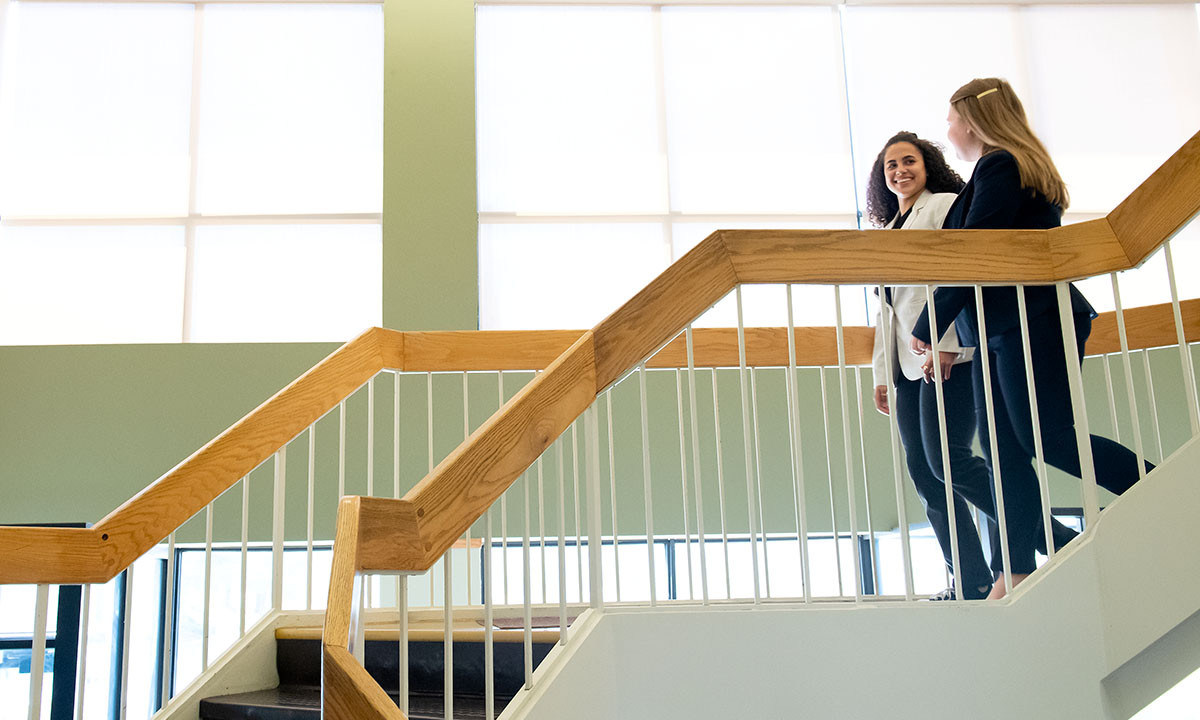 Two students walking down a stairwell
