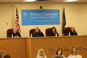 Four judges behind the judges' bench in the Wolfberg Courtroom