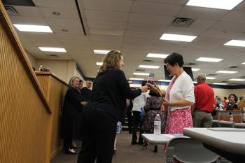 A judge handing an American flag to a recently naturalized U.S. citizen