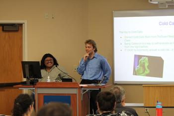 Two students at the podium with the screen to the right