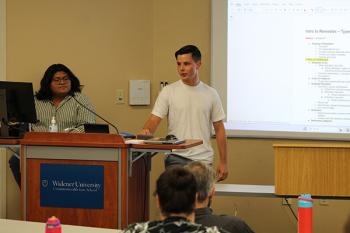 Two students at the podium with the screen to the right