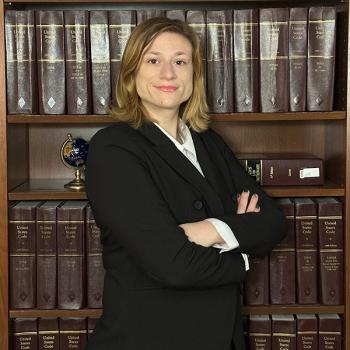 Headshot of student in front of legal books