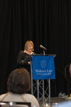 Ann Marie Yastishock speaking at the podium on stage. 